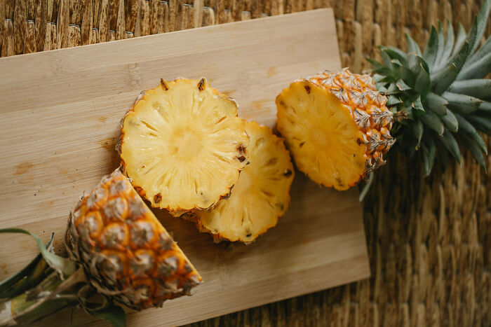 Sliced pineapple on a wooden board, showcasing health-boosting fruit qualities.