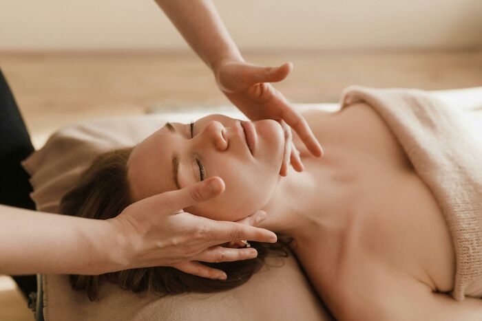 Person receiving a relaxing face massage, evoking a peaceful therapy-like experience.
