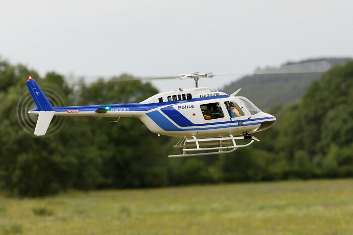 Police helicopter flying over grassy field, possibly involving hilarious overheard conversations.