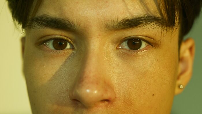 Close-up of an adult person's face, focusing on expressive eyes conveying harsh life lessons.