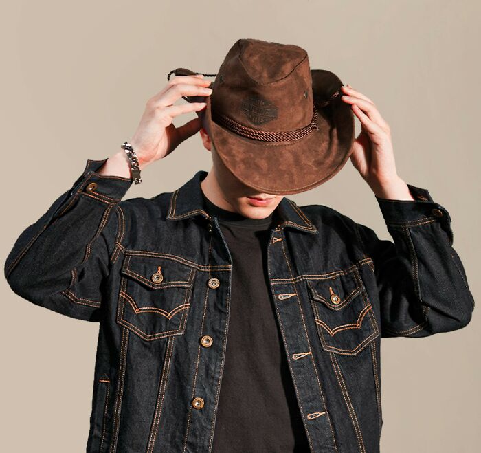 Person wearing denim jacket and brown cowboy hat, highlighting recent fashion trends people hate.