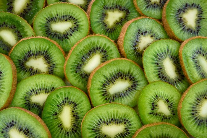 Sliced kiwi fruits showcasing vibrant green color and black seeds.