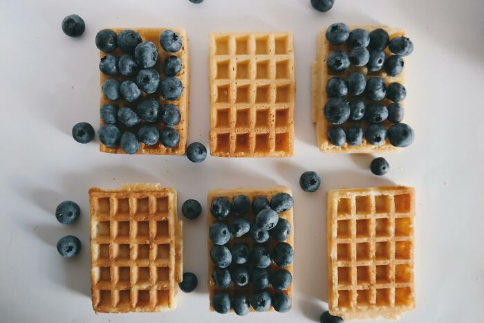 Waffles topped with blueberries, showcasing cultural differences in breakfast preferences.