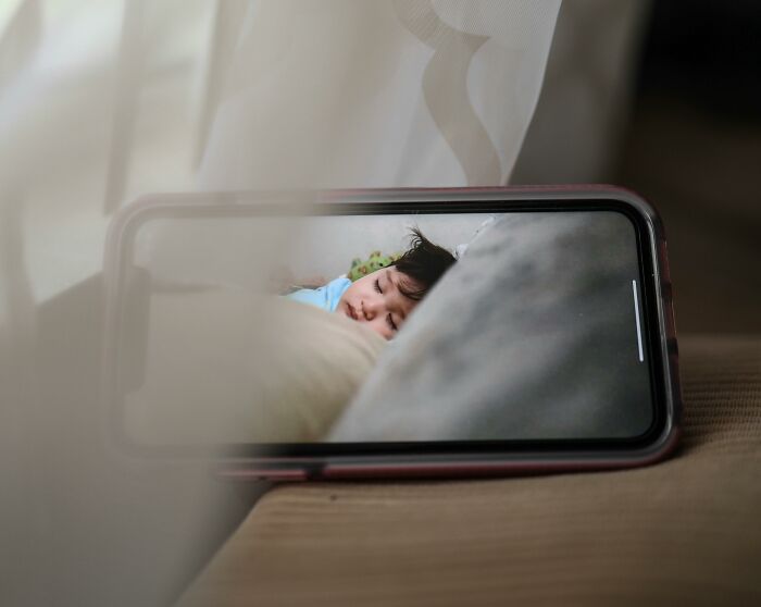 Smartphone screen showing a sleeping child, concept of hilarious overheard conversations through technology.