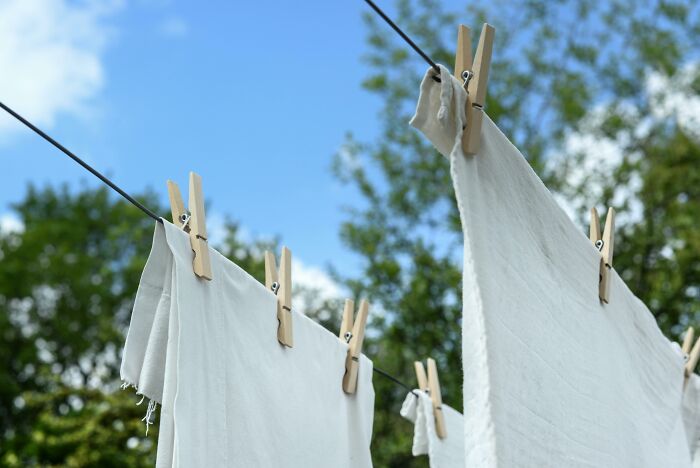 White cloths on a clothesline with wooden pegs, illustrating beautifully designed durable items for longevity.