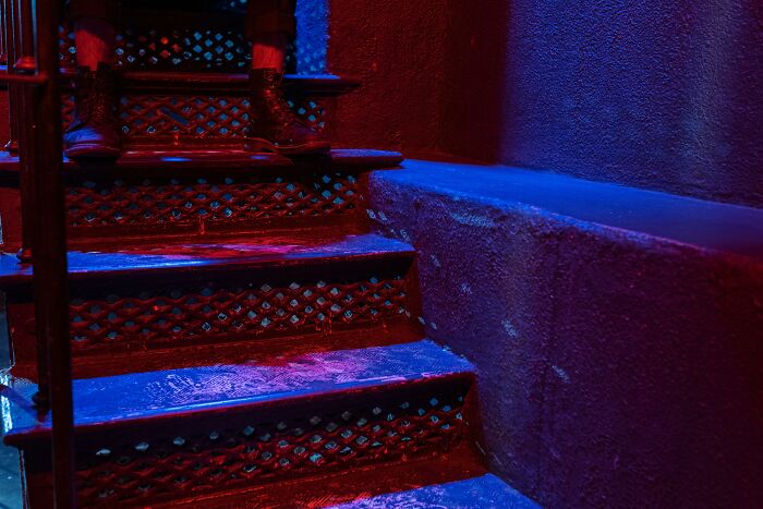 Dimly lit staircase with colorful lighting, potentially linked to weird government projects.