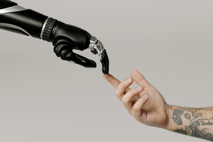 A human hand and a robotic hand reaching towards each other, symbolizing 2025 trends in technology and human interaction.