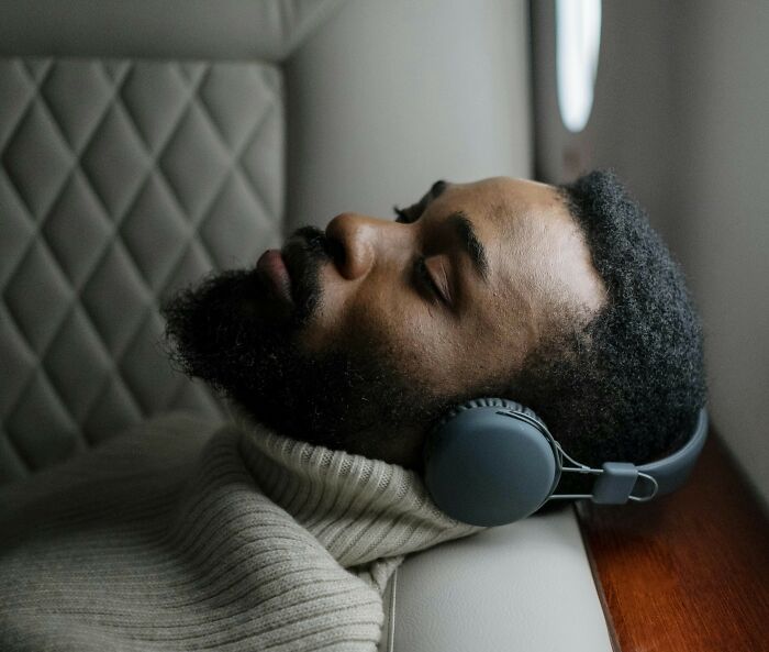 Man relaxing with noise-canceling headphones during travel for a more peaceful journey.
