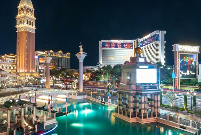 Venetian-style architecture in a cityscape at night, showcasing lights and water, related to weird government projects.