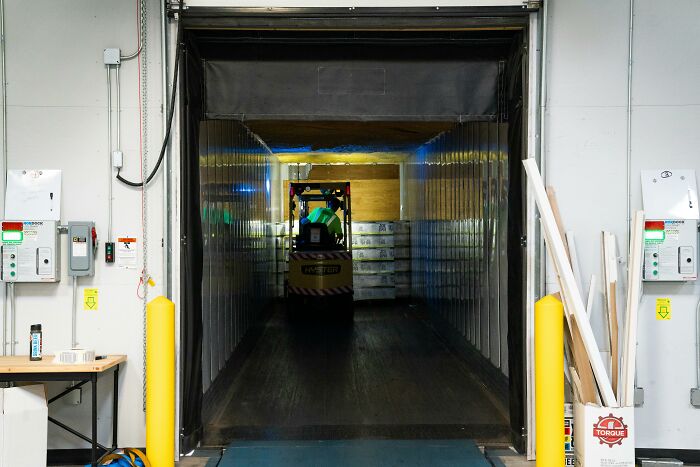 Forklift unloading at a warehouse dock, showcasing essential professions in logistics and delivery services.