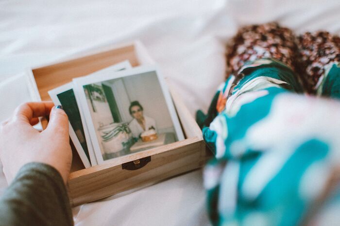 Simple Valentine's gift idea with a wooden box of cherished photographs on a cozy blanket.