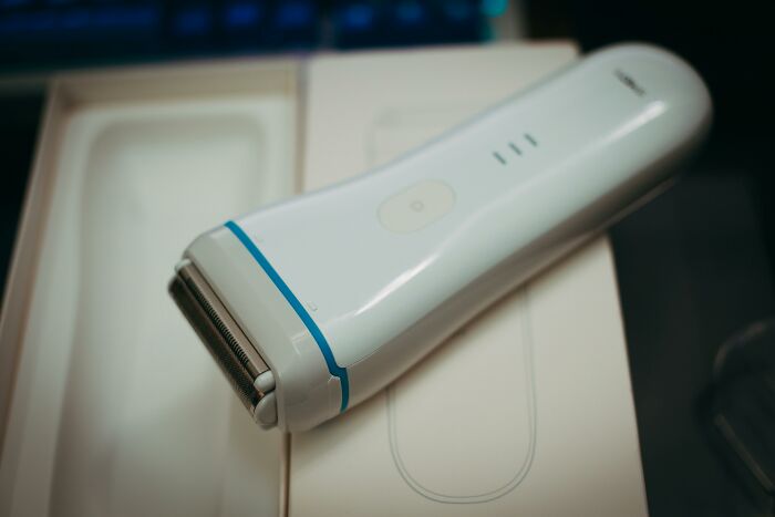 A white electric razor on a box, representing self-paying-products innovation in personal care.
