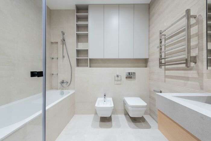 Modern bathroom interior featuring self-paying-products like a bathtub, bidet, and heated towel rack in a sleek design.