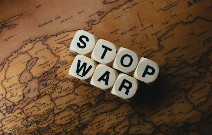 Dice spelling "STOP WAR" on a vintage map, relating to weird government projects.