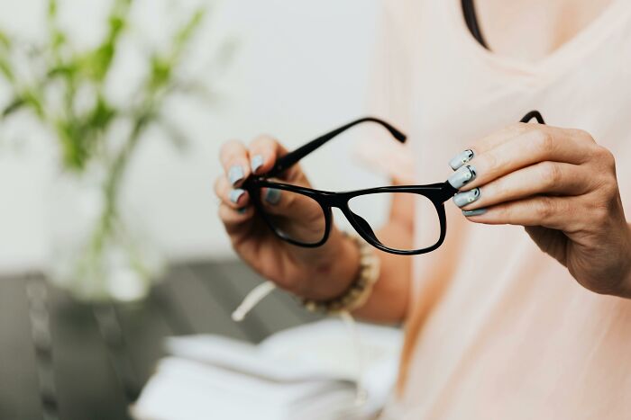 Hands holding glasses above a notebook on a table, related to Self-Paying-Products concept.