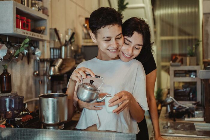 Two women enjoying coffee at home, showcasing the best perks of not having to go to the office.