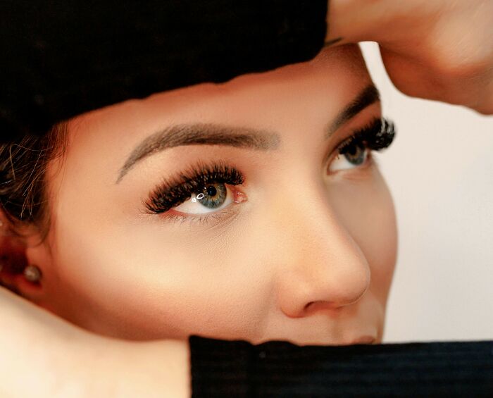 Close-up of a woman's face with bold eyelashes, reflecting recent fashion trends people hate.