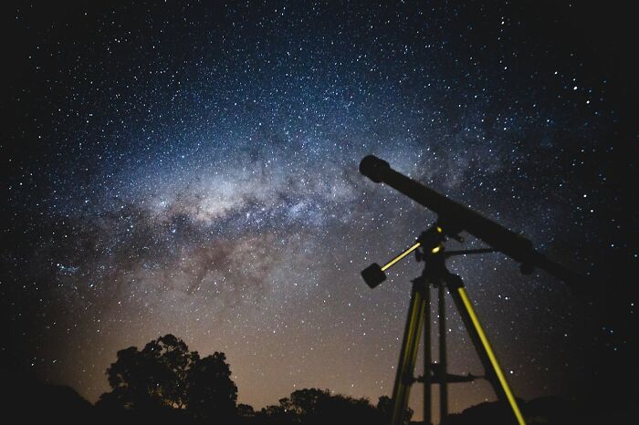 Telescope under a starry sky, challenging assumptions about people’s jobs in astronomy.