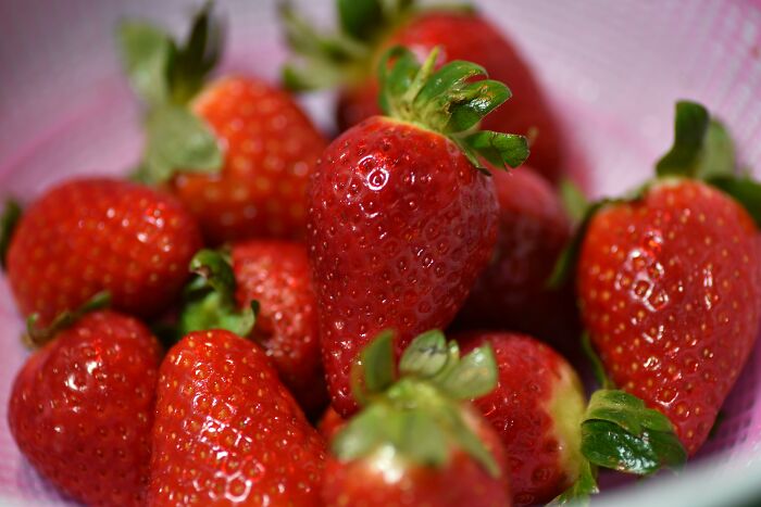 Fresh strawberries in a bowl, embodying health-boosting fruits for your fridge.