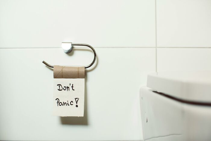 Empty toilet paper roll with handwritten note "Don't Panic" evokes vanished pop culture moments.
