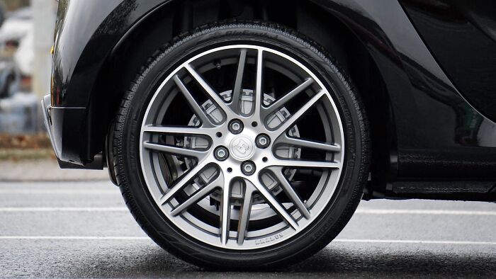 Car wheel with silver alloy rims, illustrating frugal maintenance choice and budgeting.