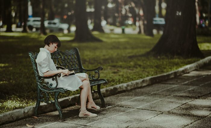 Person reading on a park bench, experiencing culture shocks abroad.