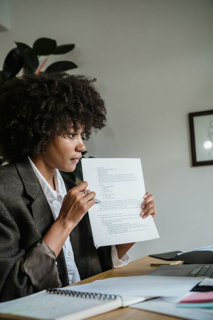 Professional woman reviewing documents at a desk, illustrating ways people got revenge on someone in power.
