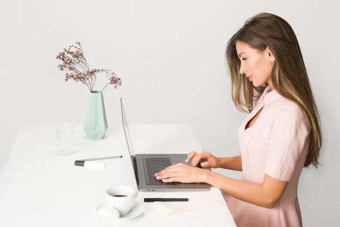 Woman at desk with laptop, vase, and coffee, highlighting common job stereotypes.