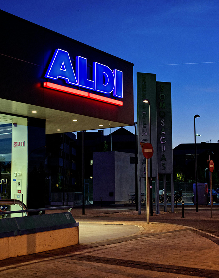 Aldi store exterior at night with bright signage.