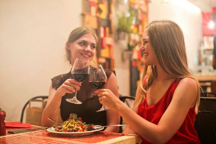 Two adult people sharing wine and smiles at a restaurant, enjoying dinner and conversation.