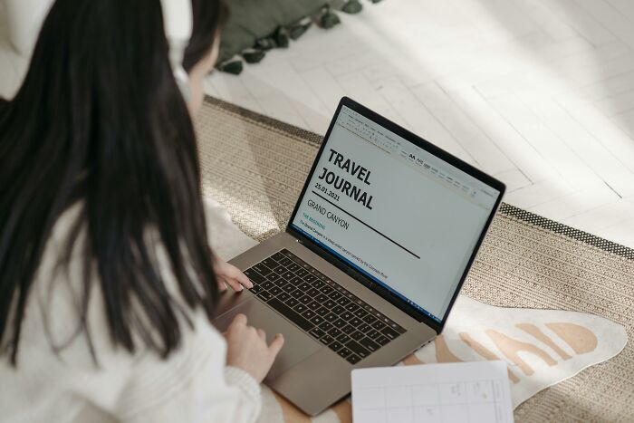 Person typing on a laptop, working on a travel journal about the Grand Canyon, illustrating skills people lack in digital tasks.