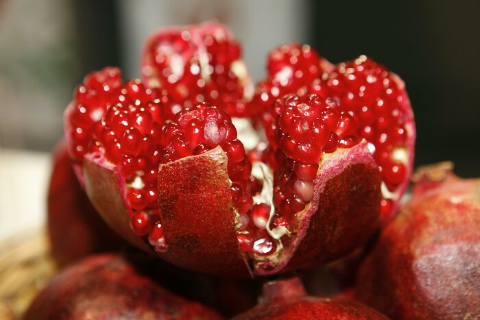 Opened pomegranate displaying its vibrant red seeds, a health-boosting fruit.