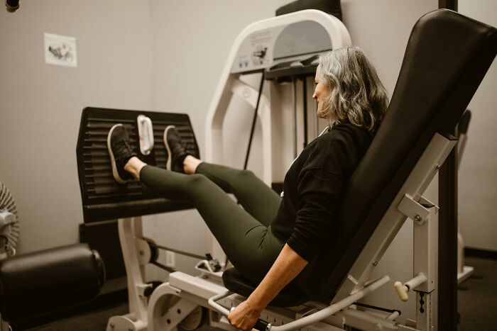 Woman using a leg press machine in a gym, illustrating common fitness myths.
