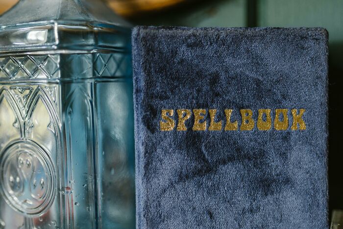 Blue spellbook next to a glass bottle, related to hilarious overheard conversations.