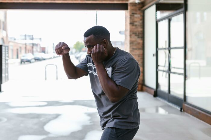 Man practicing boxing moves outdoors, wearing a gray shirt, related to hilarious conversations context.