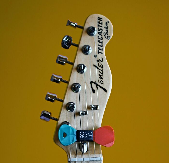 Fender Telecaster headstock with colorful guitar picks, showcasing beautiful design and durability.