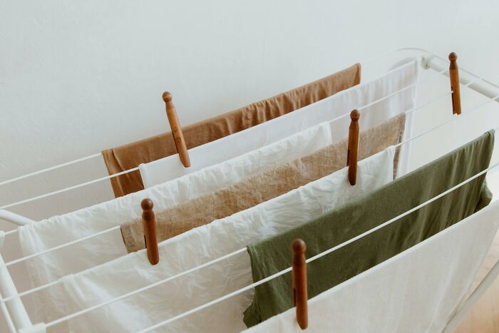 Clothes drying on a rack with wooden clips, representing self-paying-products in home essentials.