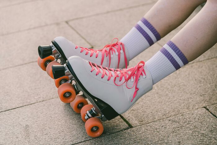 Roller skates with pink laces on a sidewalk, evoking hilarious conversations during a fun day out.