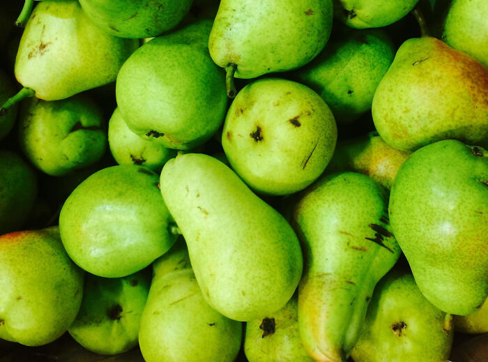 Green pears piled together, showcasing health-boosting fruits.