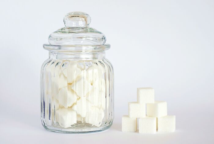 Sugar cubes in a glass jar and stacked beside it, highlighting an unpopular opinion poll topic.