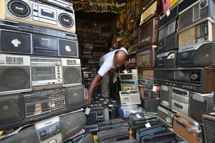 Man surrounded by vintage radios, representing outdated technology predictions.