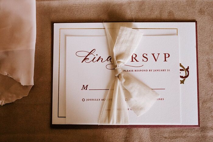 Wedding RSVP card with elegant ribbon, highlighting event details, a common concern for wedding guests.