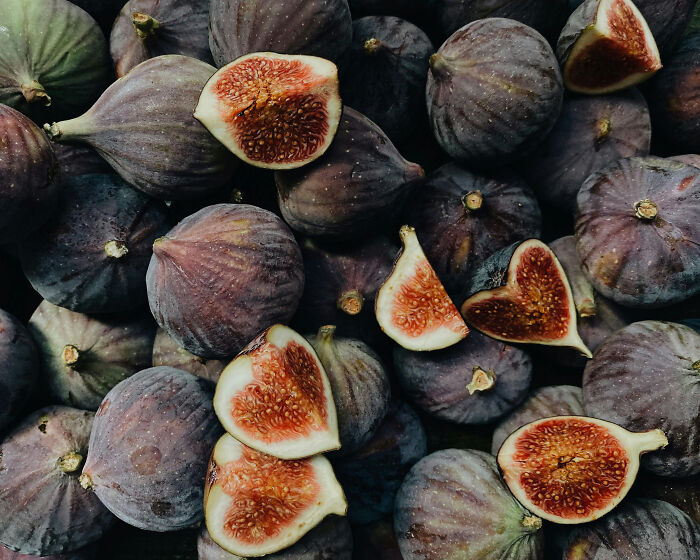 Fresh figs halved, showcasing their rich interior, a perfect health-boosting fruit to store in your fridge.