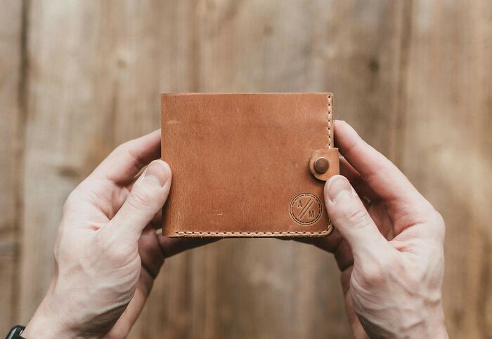 Hands holding a durable, beautifully designed leather wallet, showcasing craftsmanship and longevity.