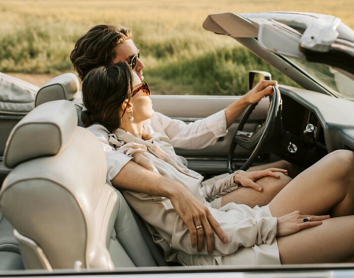 A couple embracing in a convertible, enjoying a leisurely drive, conveying love and togetherness.