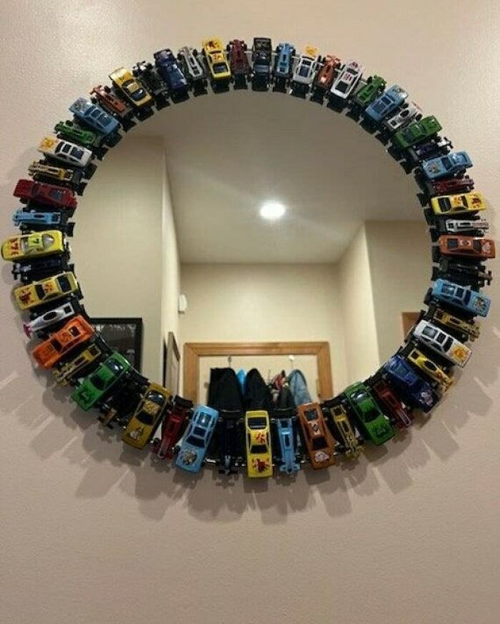 Mirror decorated with recycled toy cars to inspire recycling.