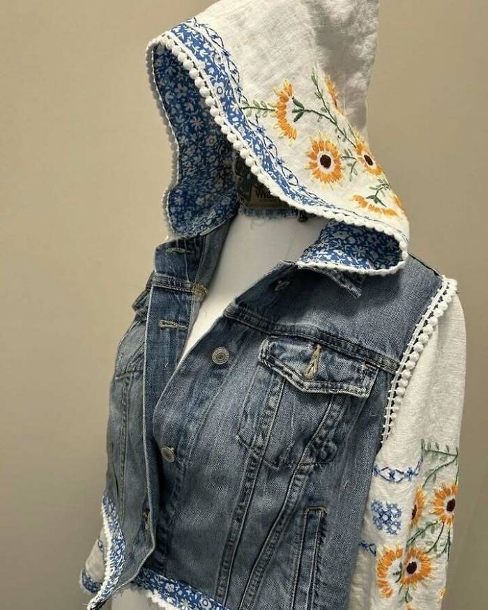 Denim jacket with embroidered floral fabric hood and sleeves, highlighting creative recycling.