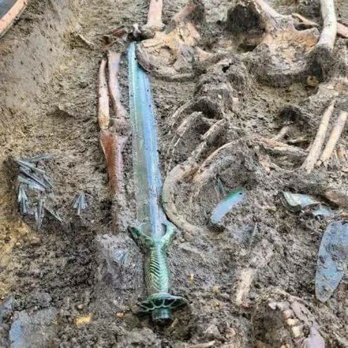 Ancient sword discovered in an archaeological dig, showcasing interesting historical artifacts buried in the ground.