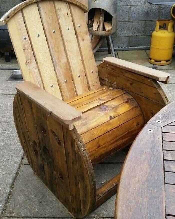 Wooden chair crafted from recycled materials, resting on a patio.
