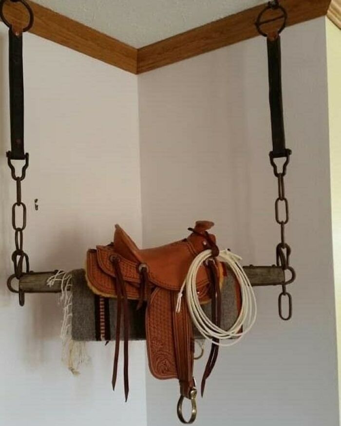 Recycled saddle repurposed as a hanging corner shelf, showcasing creative recycling ideas.